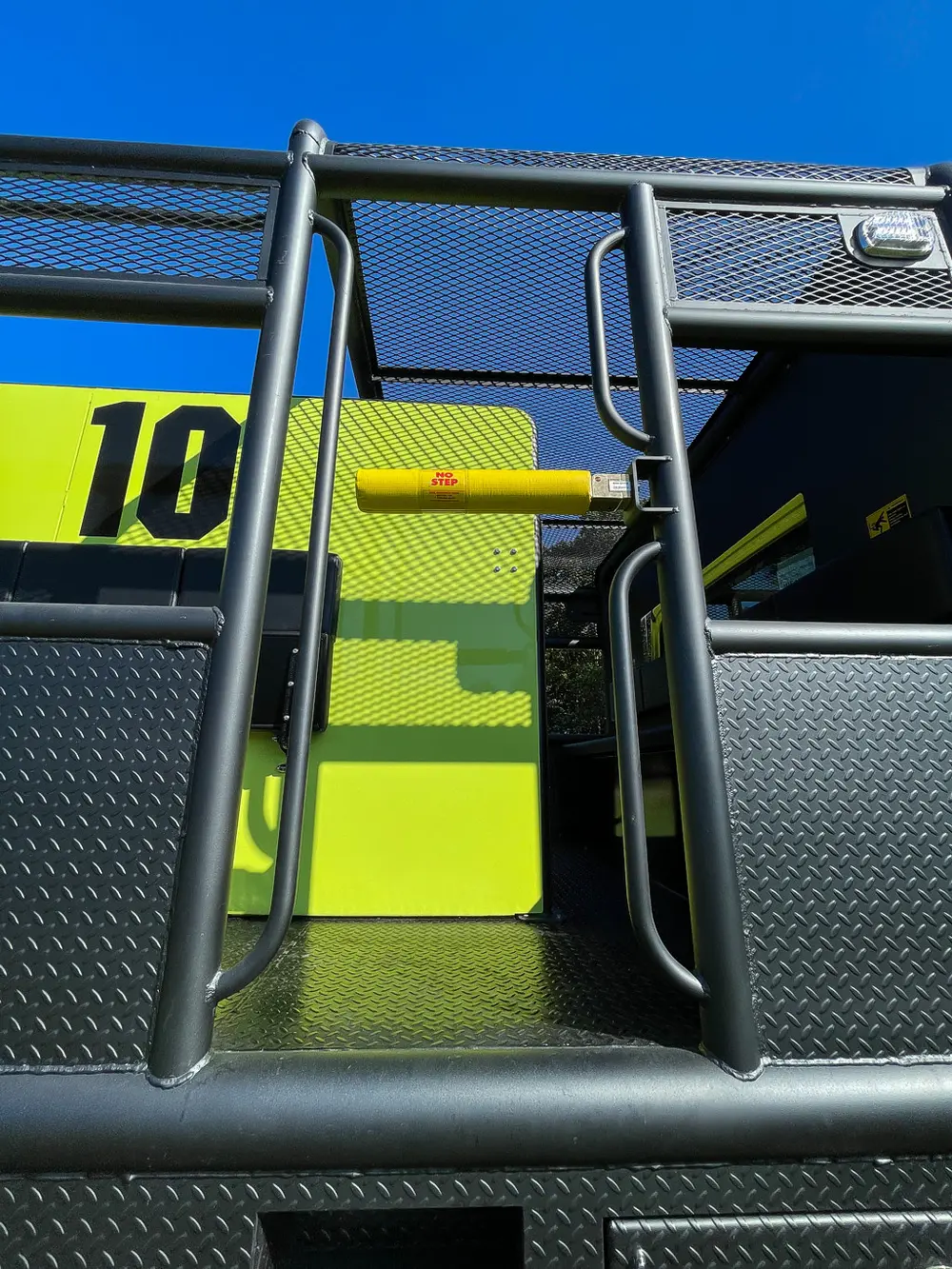 Side ladder section and yellow handhold near body corner.