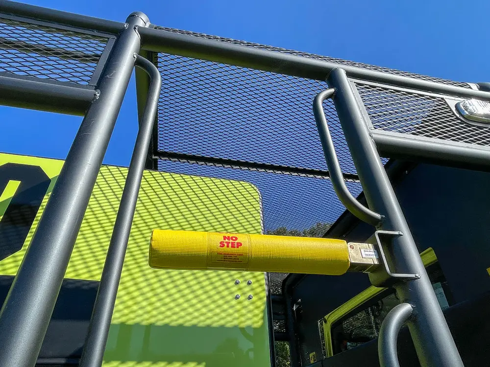 Upper side rail and ladder entry with yellow grab bar.