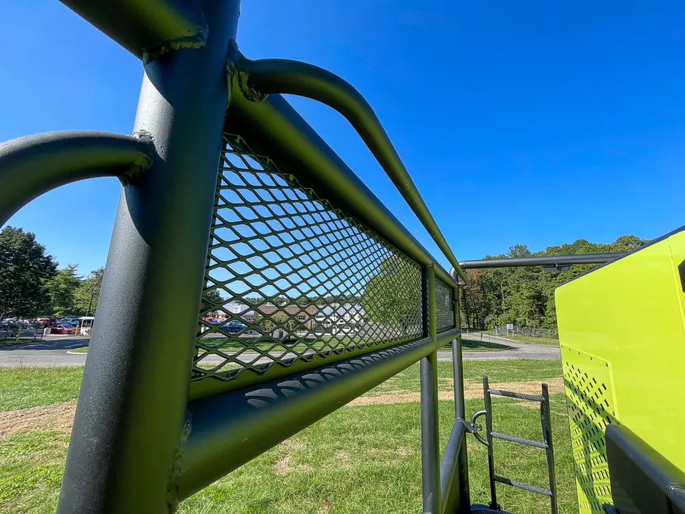 Rear side cage corner and handrail near platform edge.