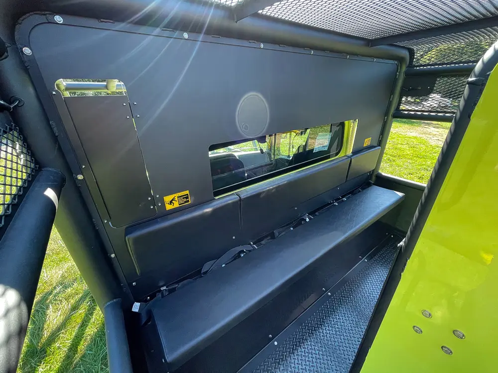 Open upper side shelf near tank with long tools stored.