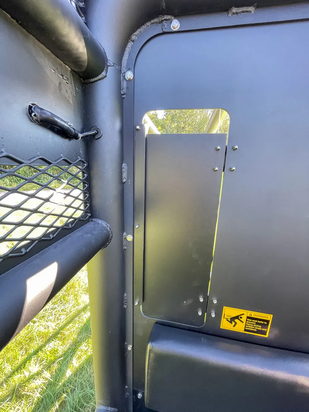 Tall narrow side cabinet door open on rear body corner.