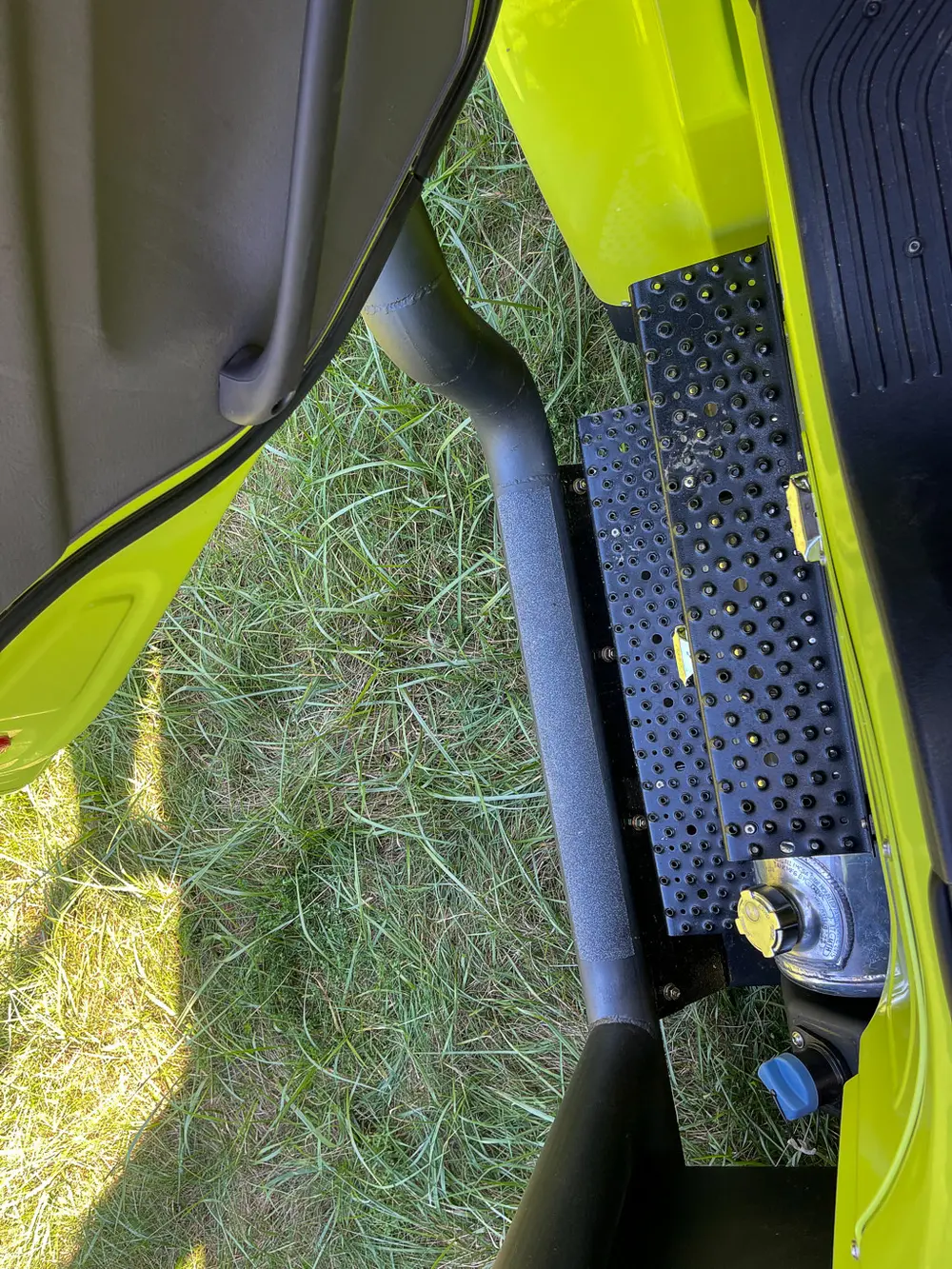 Close-up of perforated side step below door.