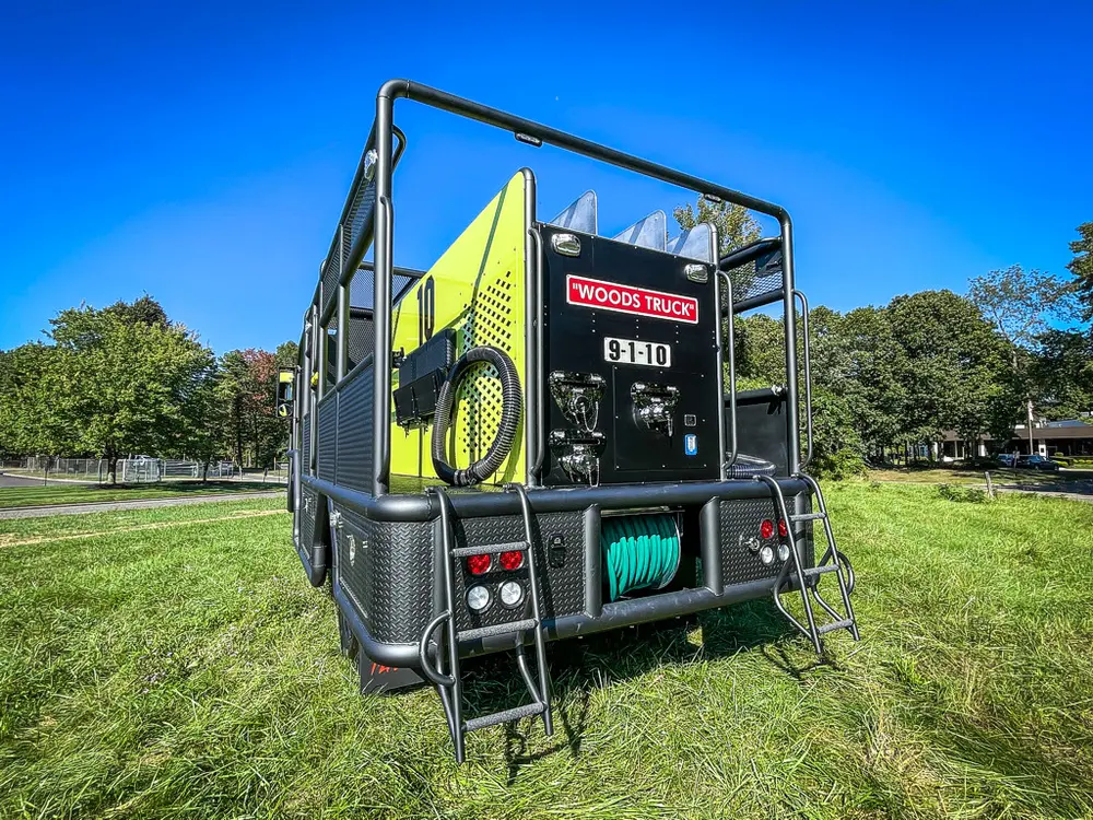 Rear corner view with fold-down step ladder visible.