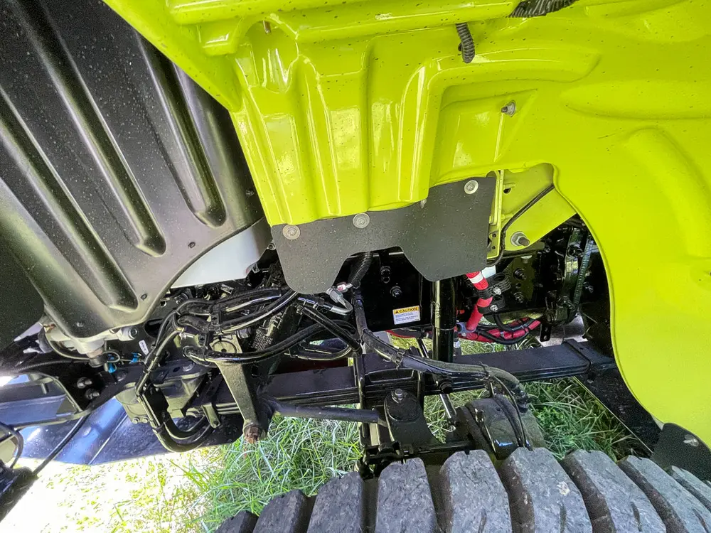 Rear axle and suspension close-up under body panel.
