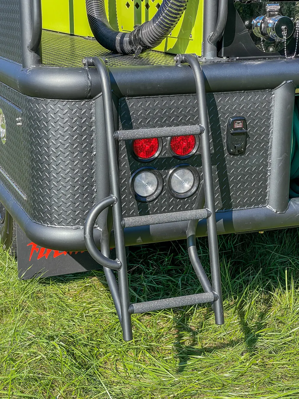 Rear corner control lights and ports beside ladder.