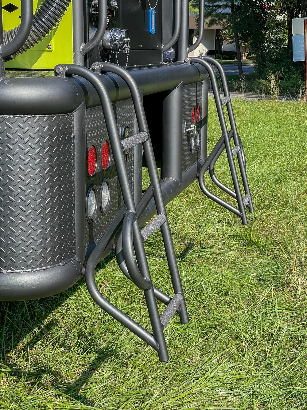 Rear corner ladder and taillight cluster near bumper.