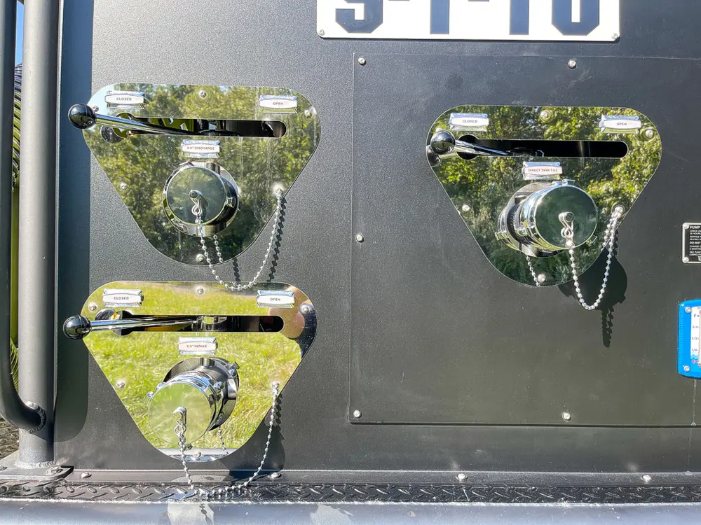 Close-up of polished hose coupling ports on rear panel.