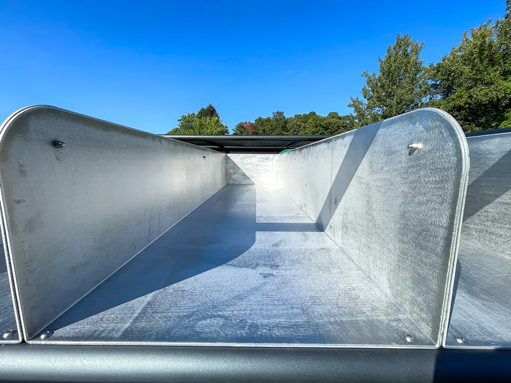 Interior of metal trough with smooth curved sidewall.