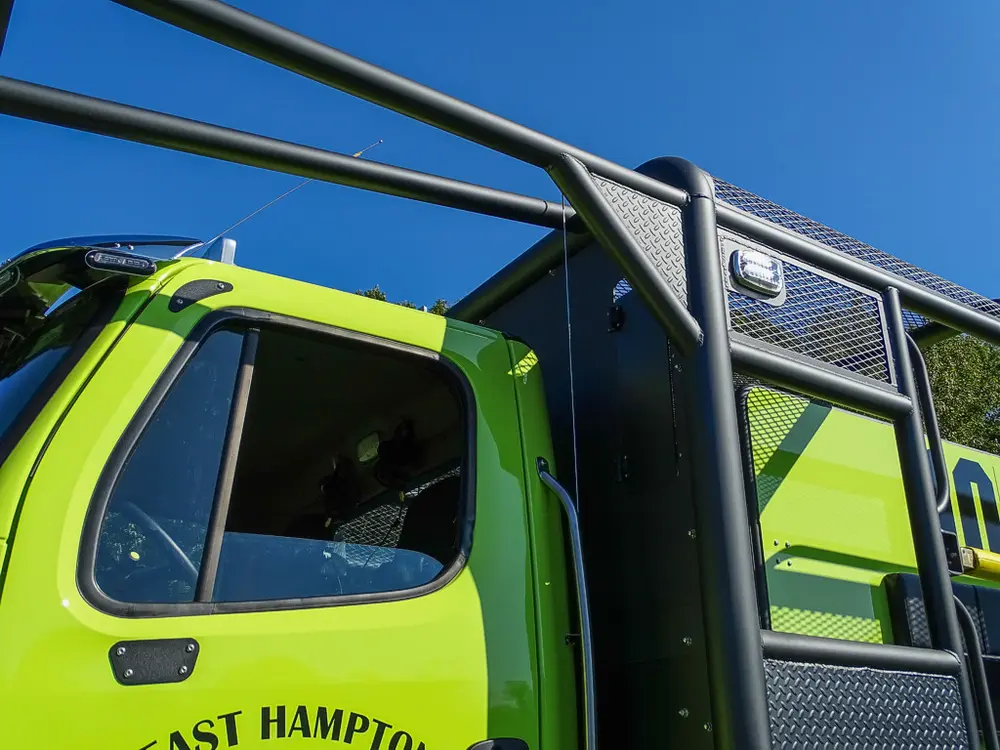 Cab side and cage frame around open front door area.