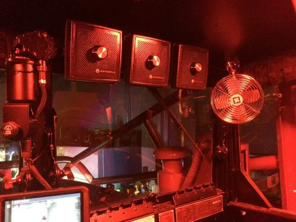 Exterior view of small fire truck showing cab, body compartments, and wheel/tire area.