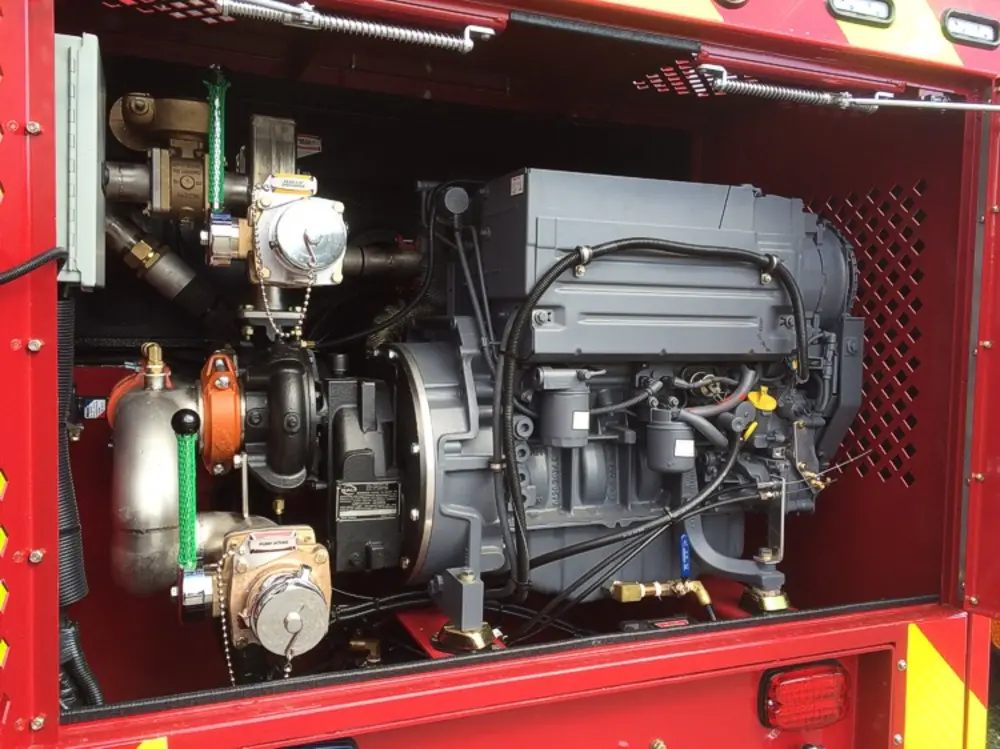 Exterior view of small fire truck showing cab, body compartments, and wheel/tire area.