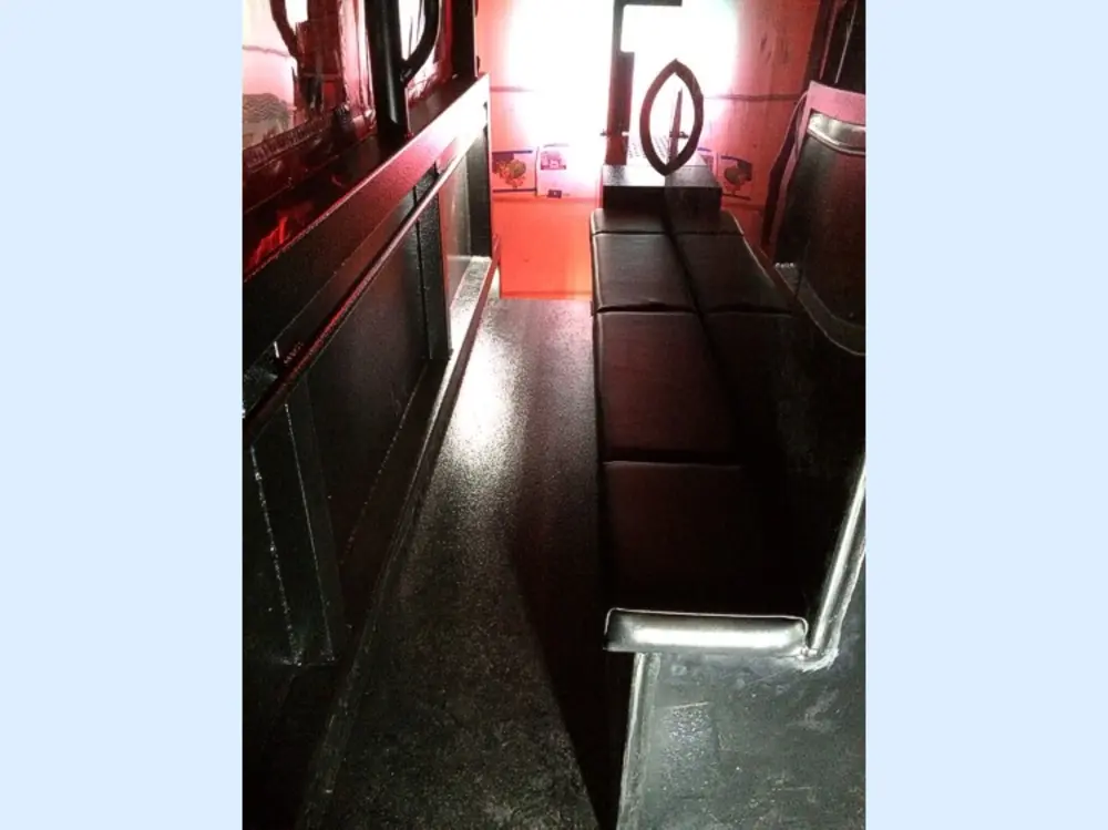 Exterior view of small fire truck showing cab, body compartments, and wheel/tire area.