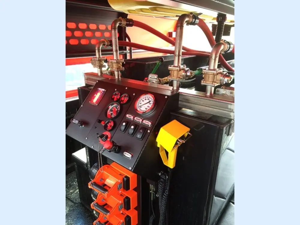 Exterior view of small fire truck showing cab, body compartments, and wheel/tire area.