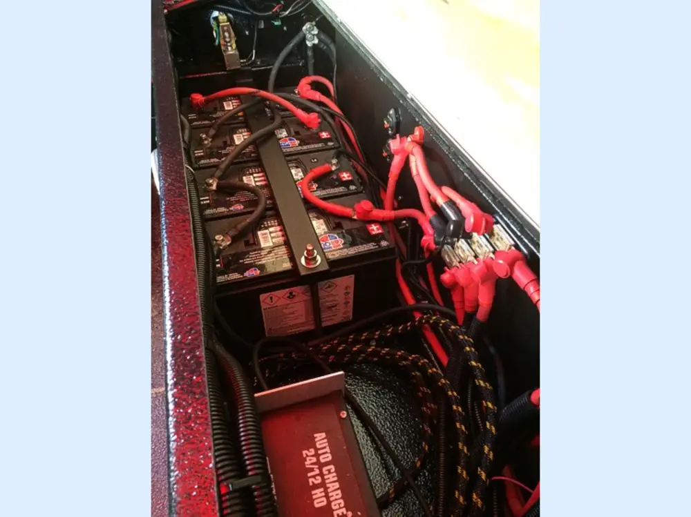 Exterior view of small fire truck showing cab, body compartments, and wheel/tire area.