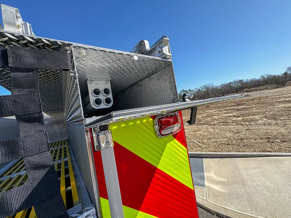 Rear corner with open upper compartment and chevron-striped body panel.