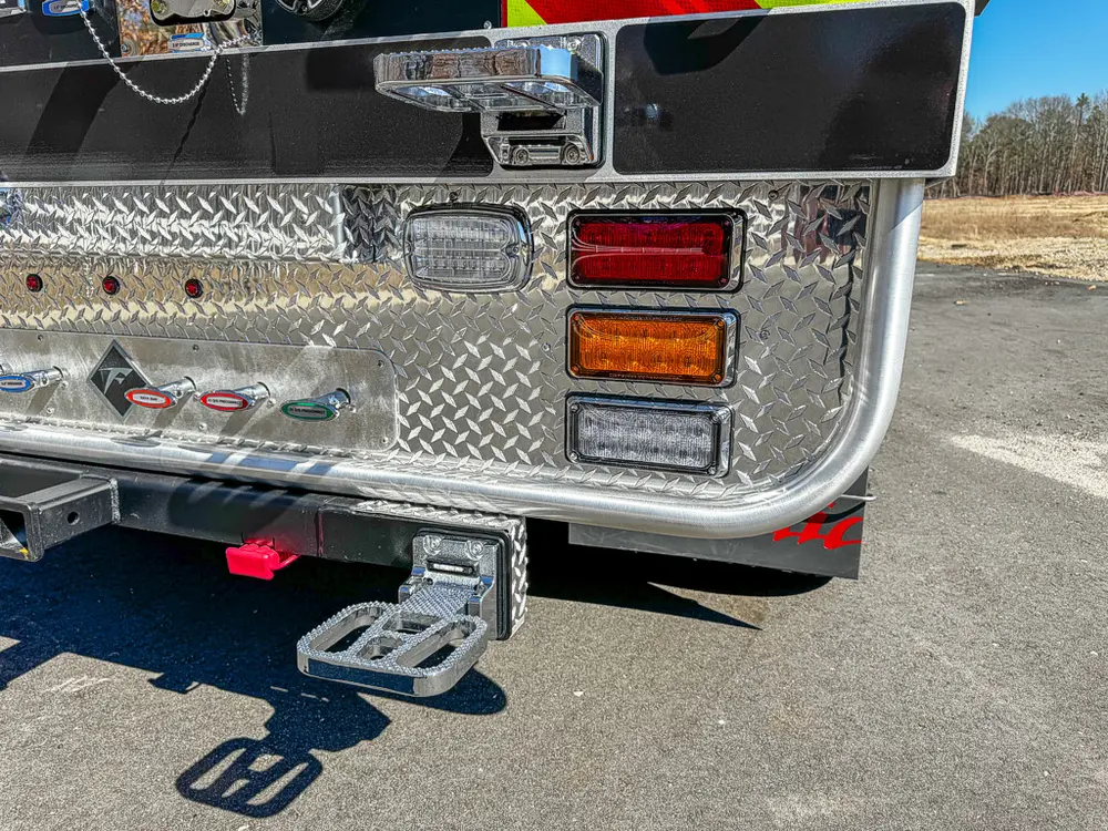 Lower rear corner close-up with taillight cluster and fold-out step.