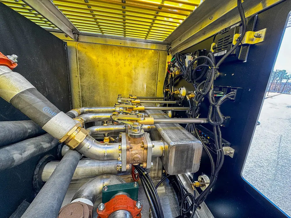 Wide pump compartment view with multiple hoses and control valves.