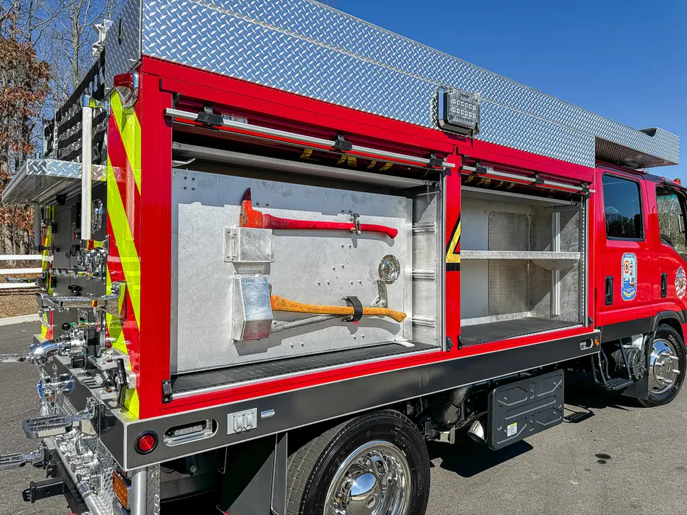 Long left-side compartment open with mounted hand tools on panel.
