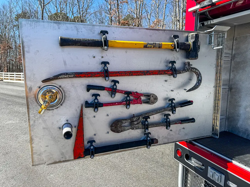 Open side door panel with assorted mounted nozzles and hand tools.