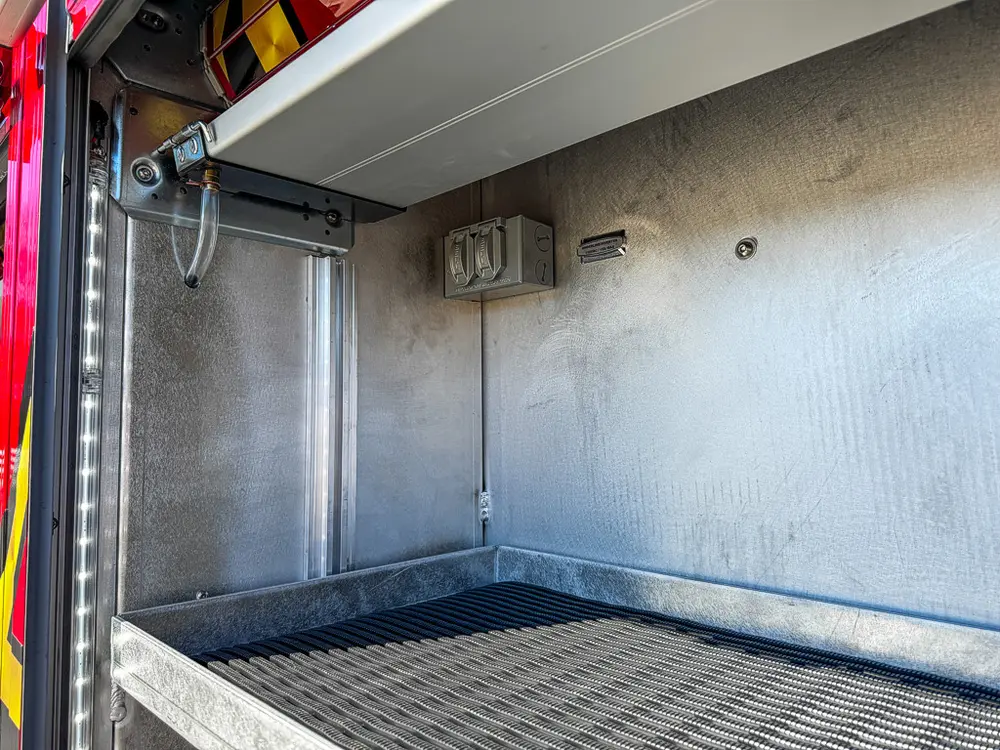 Compartment interior close-up with shelf and mounted outlet panel.