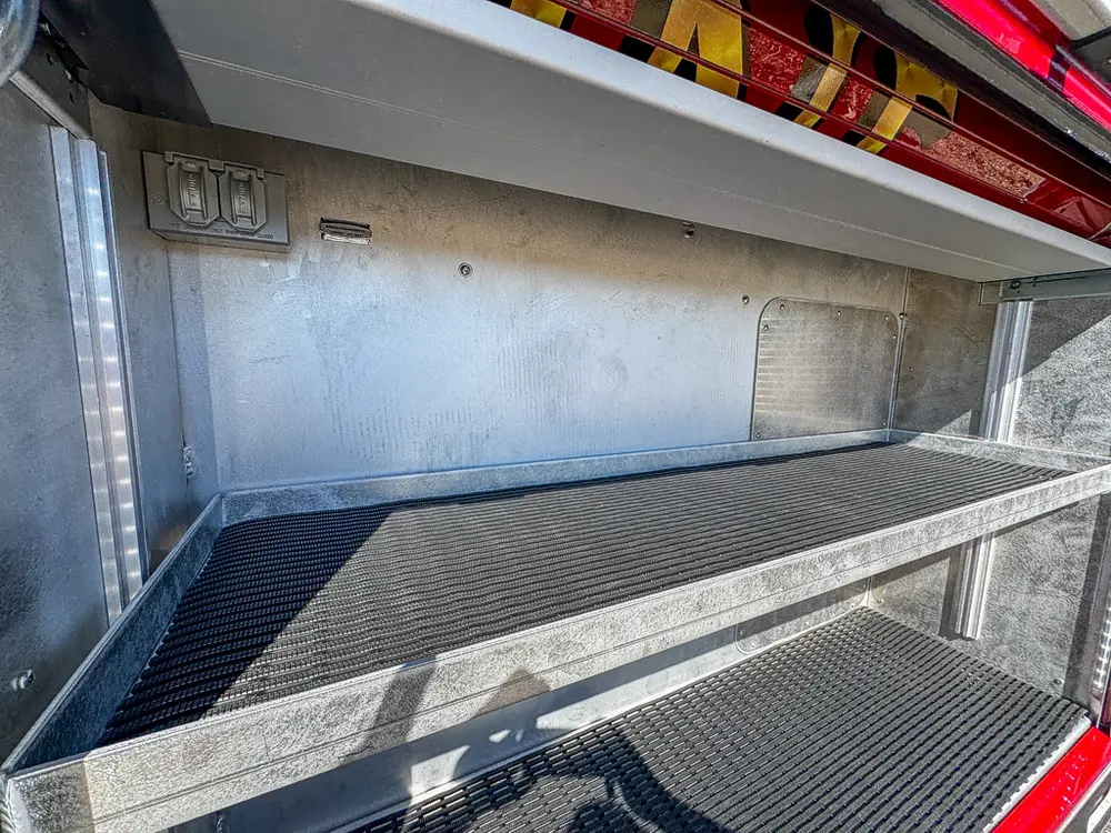 Open long side compartment with shelf and ribbed floor surface.