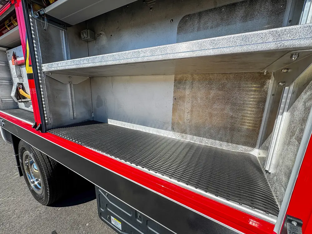 Side compartment close-up with fold-down tray and empty bay.