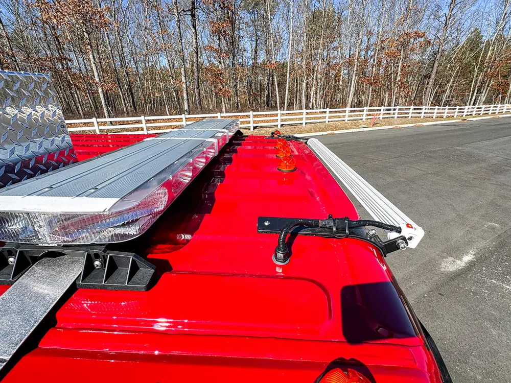 Upper deck rail and folded ladder close-up along the red body top.