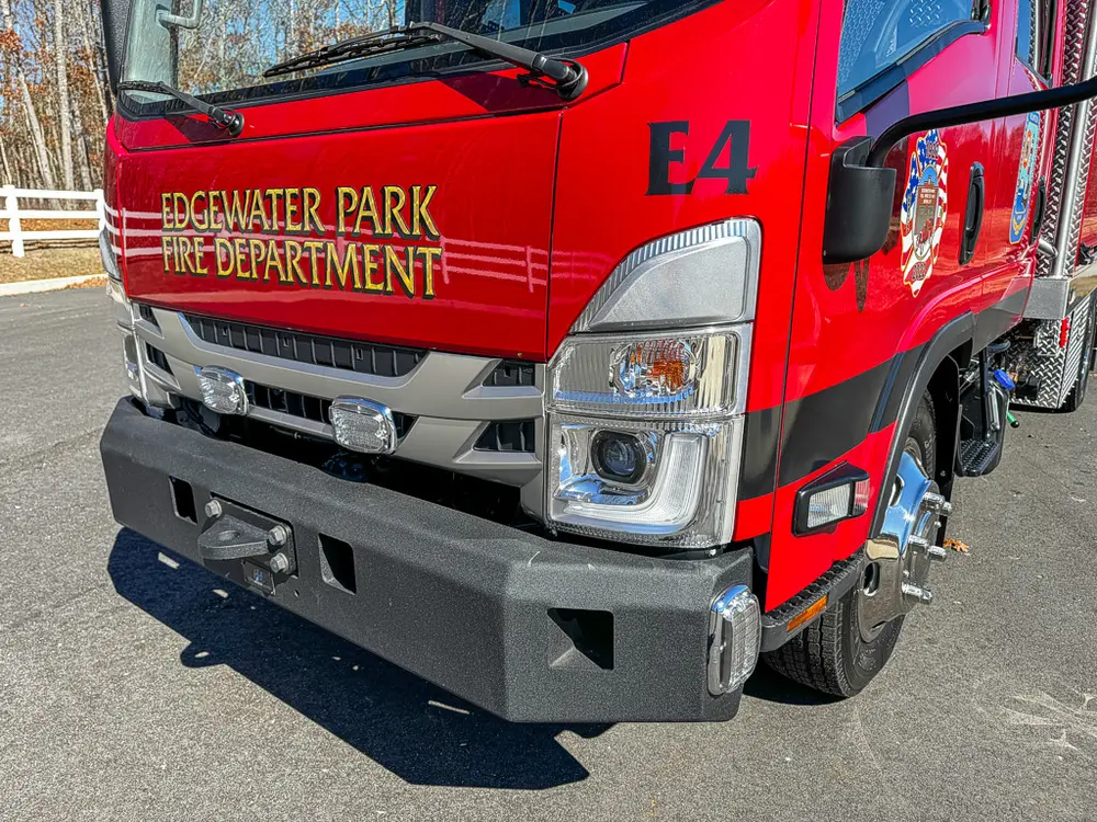 Front-left corner close-up with grille, bumper, and side stripe.