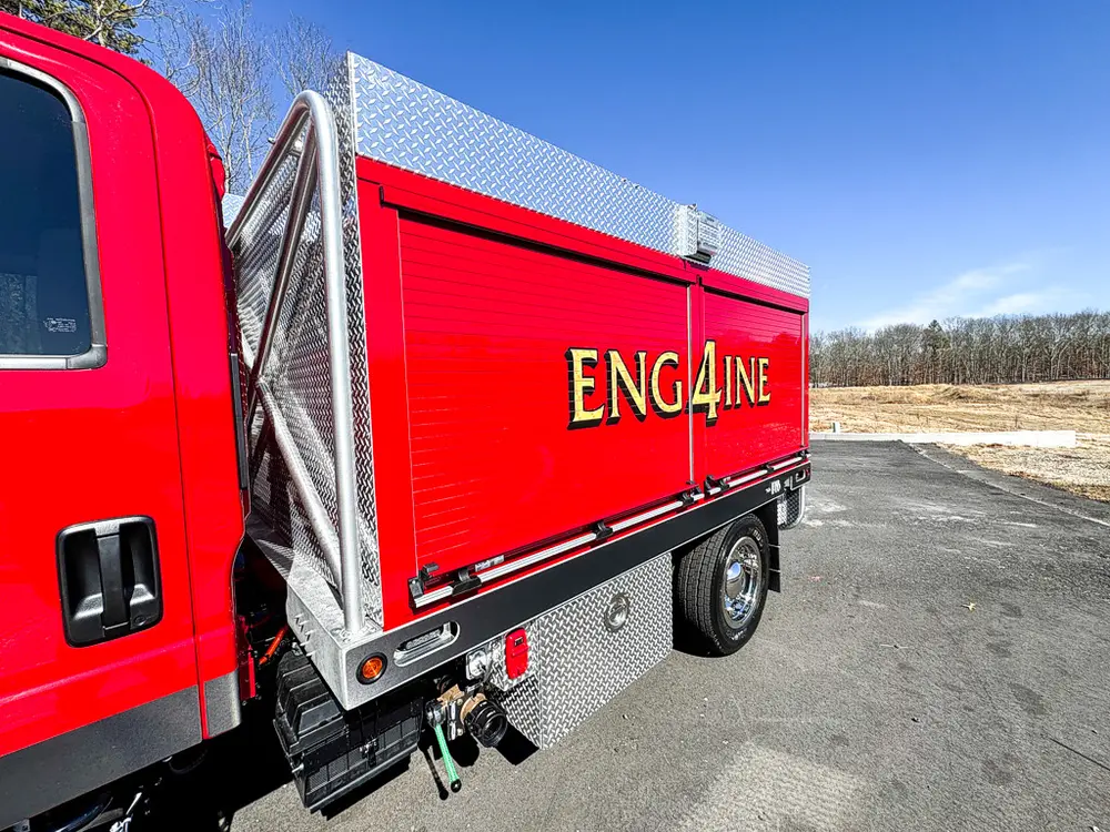 Right rear body side with compartment door opened upward.