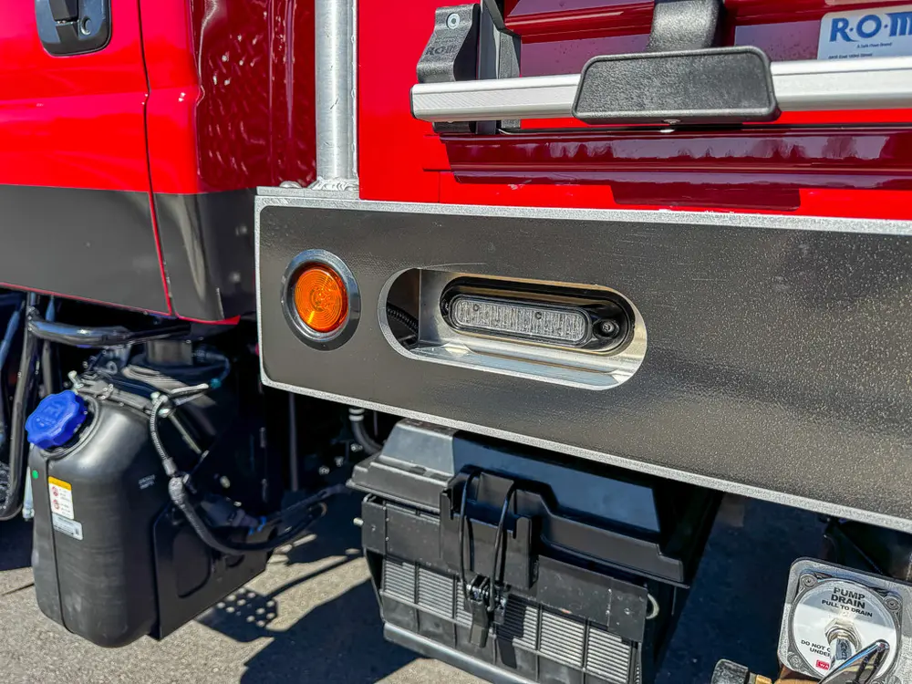 Lower side body close-up with marker light and underbody components.