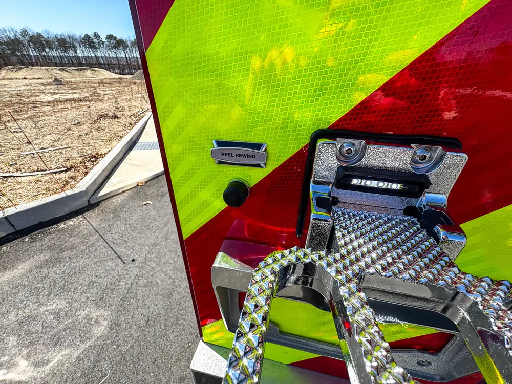 Rear step and bumper corner close-up with mounted license light.
