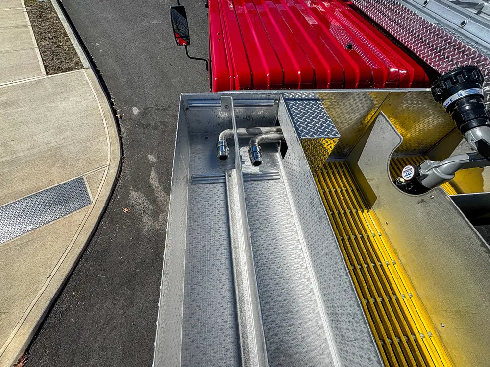 Top walkway view with mounted deck gun and red hose cover.