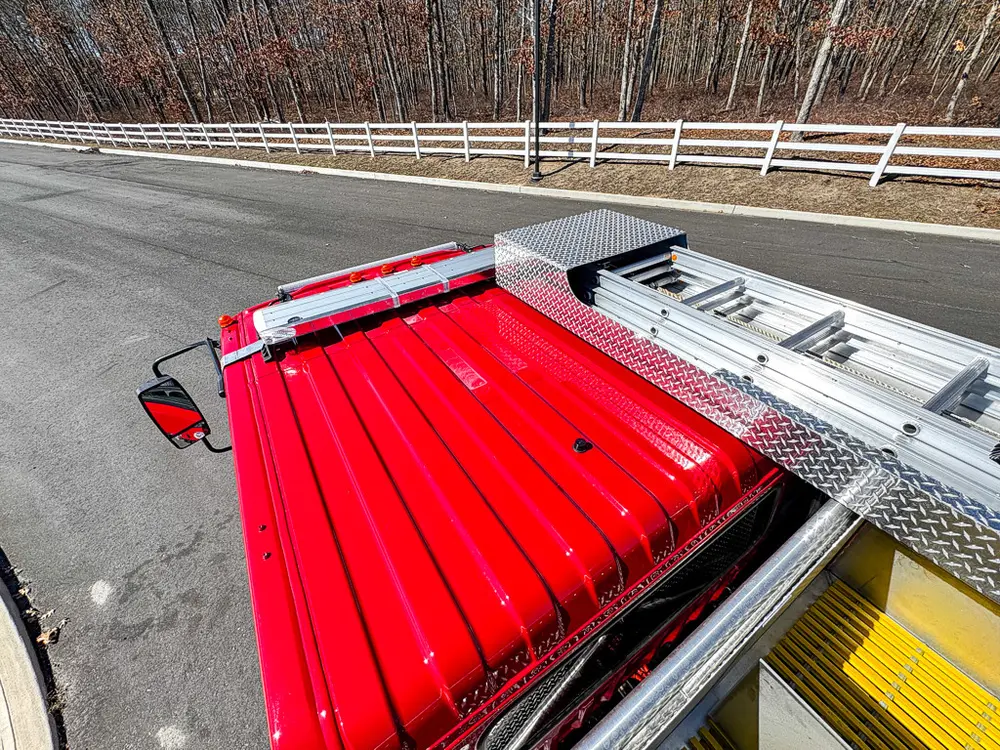 Rear upper deck with red hose cover and side rail visible.