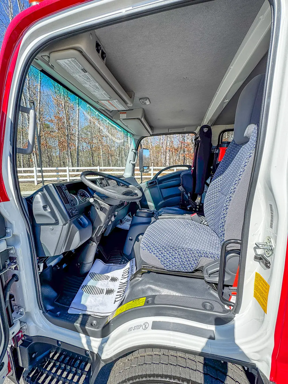 Driver-side interior view with steering wheel and front seat.