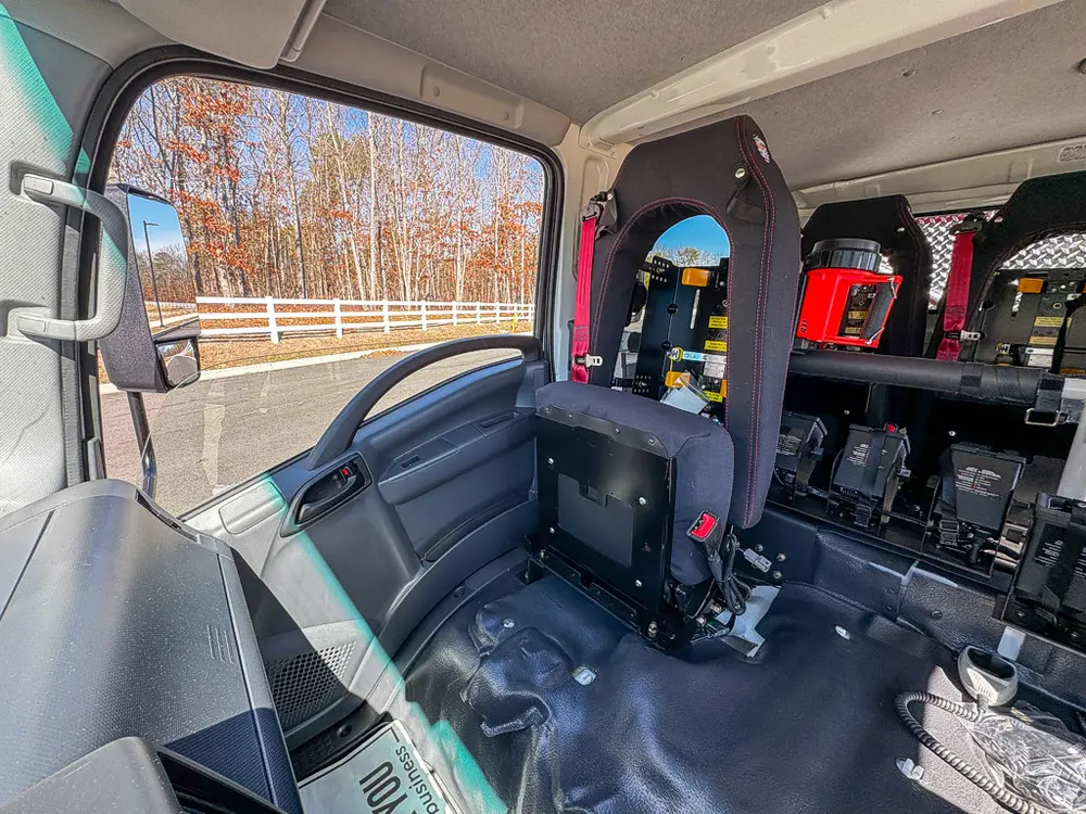 Rear cabin area from side door showing seatbacks and mounted equipment.