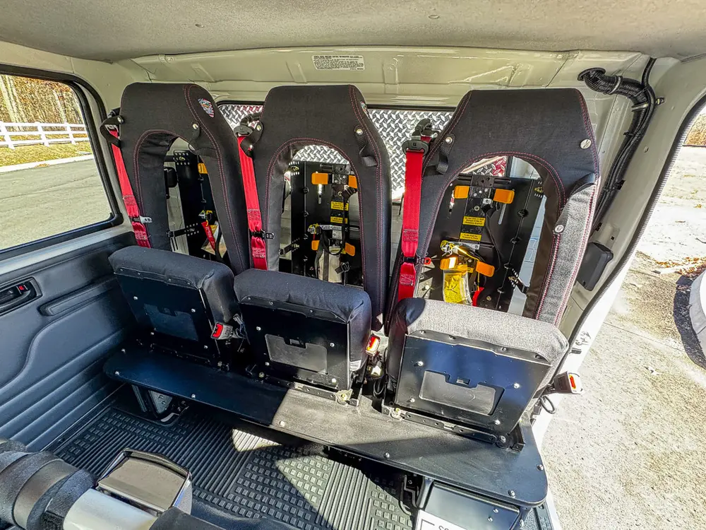Rear bench and mounted child-seat backs viewed from side door.