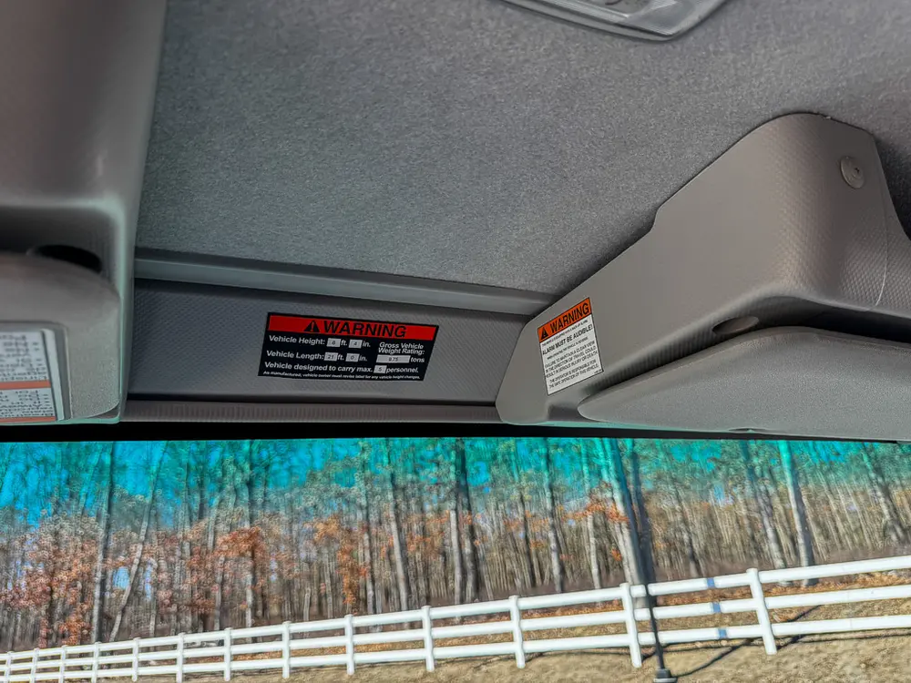 Upper interior headliner close-up with warning label panel.