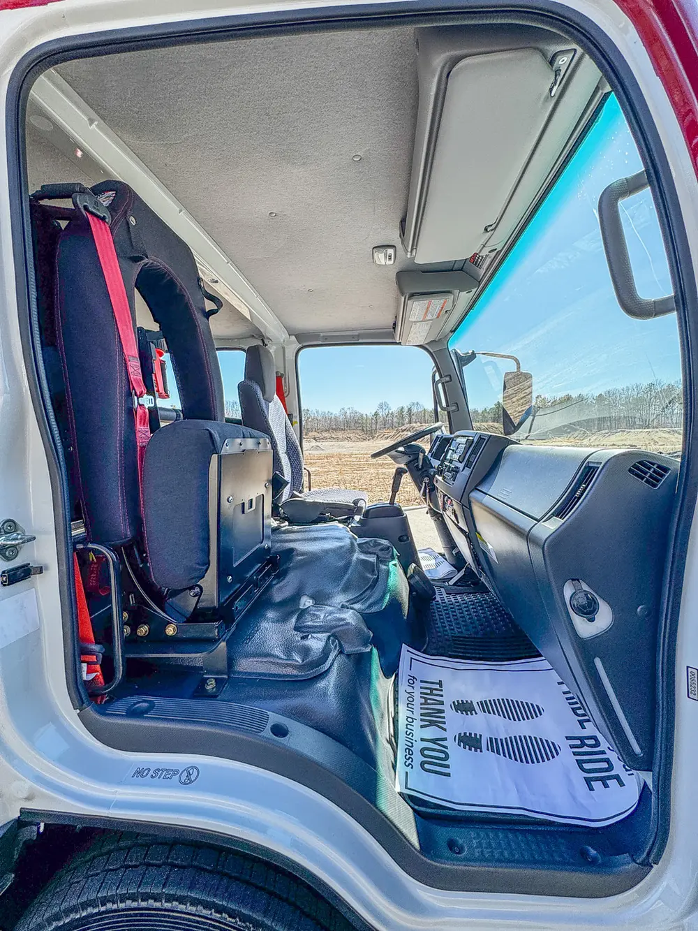 Front cabin viewed from passenger side with steering wheel and console.