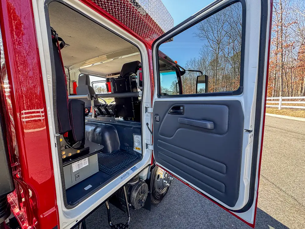 Open side door view into rear cabin with bench and interior storage.
