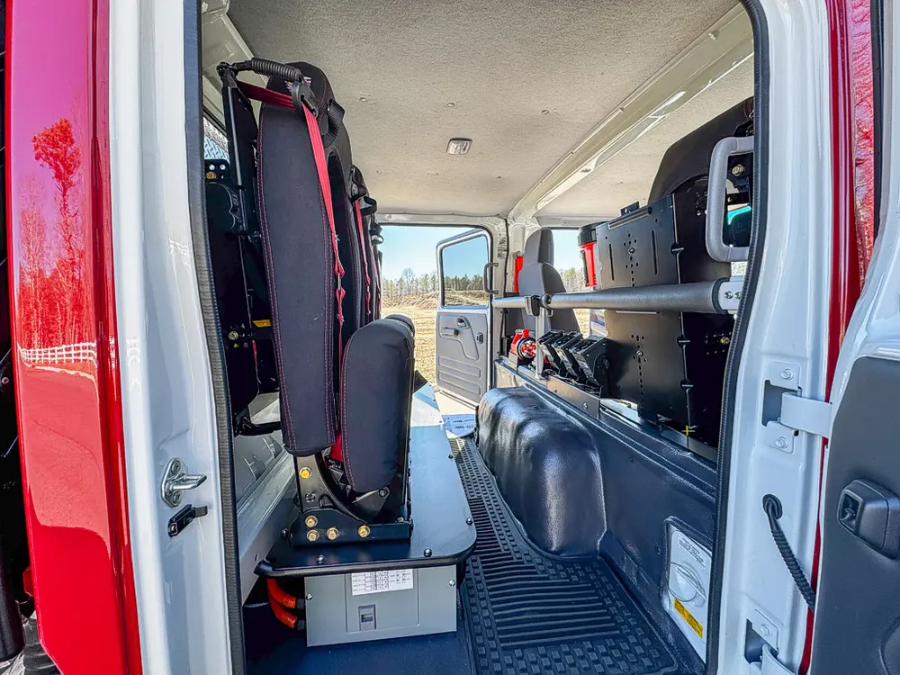 Rear cabin interior view with fold-down seats and side storage.