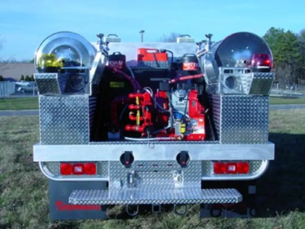 Exterior view of small fire truck showing cab, body compartments, and wheel/tire area.