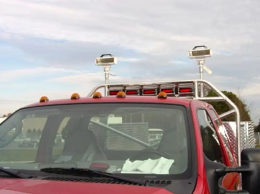 Exterior view of small fire truck showing cab, body compartments, and wheel/tire area.