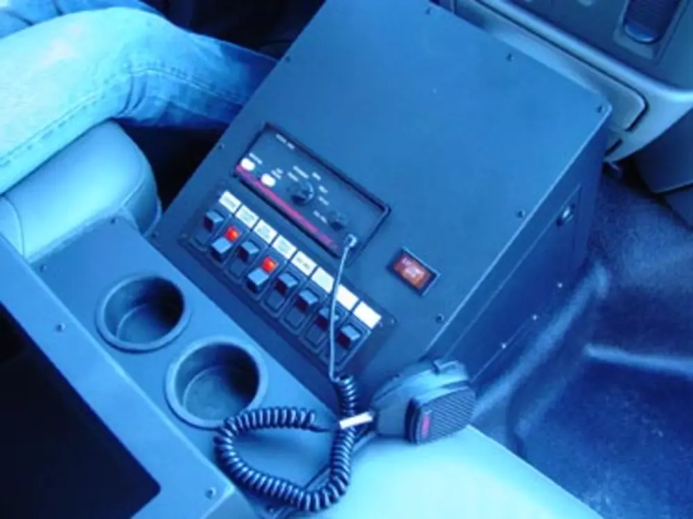 Exterior view of small fire truck showing cab, body compartments, and wheel/tire area.