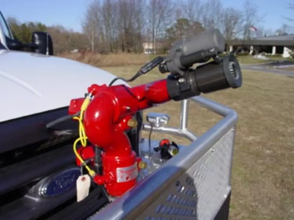Exterior view of small fire truck showing cab, body compartments, and wheel/tire area.