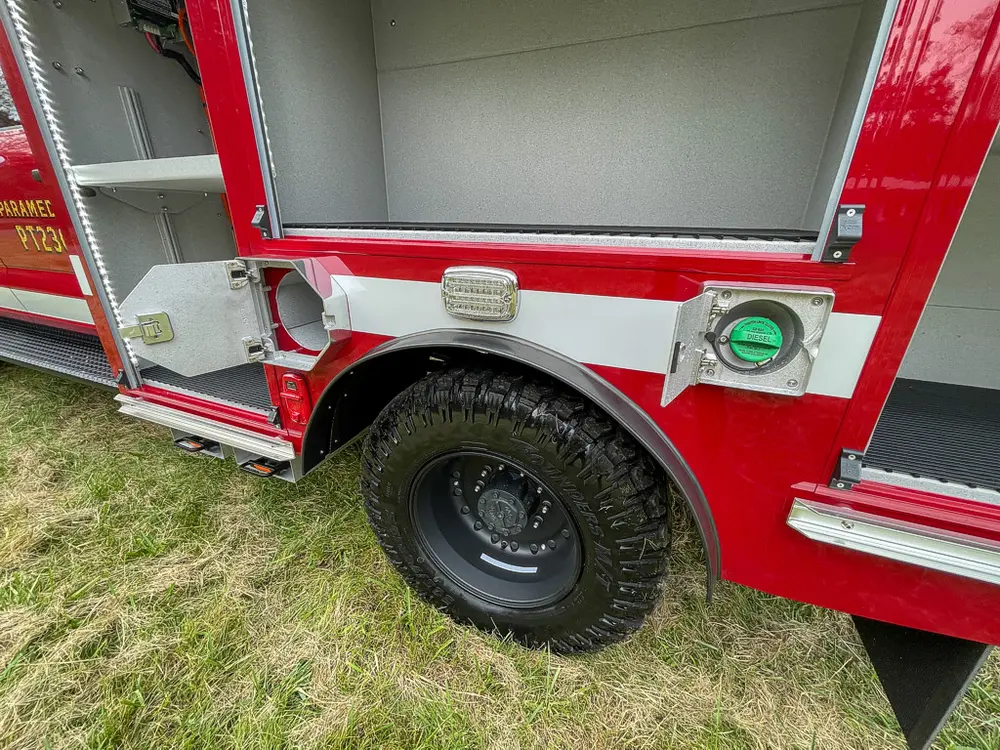 Rear side compartment opening above wheel with small utility port.