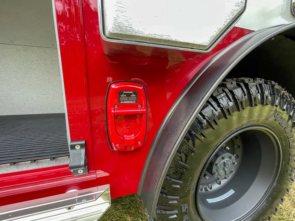 Rear quarter panel and wheel close-up with compartment doors open.
