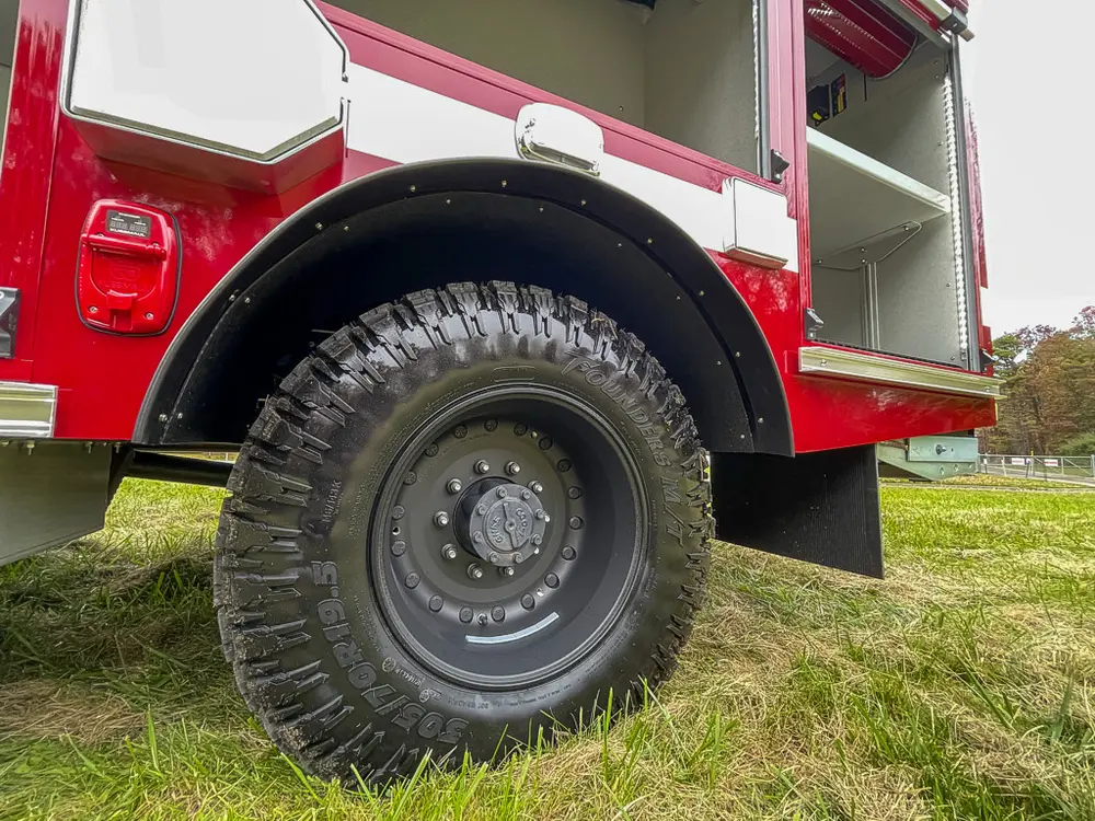 Close-up of heavy-duty rear tire and lower body compartments.