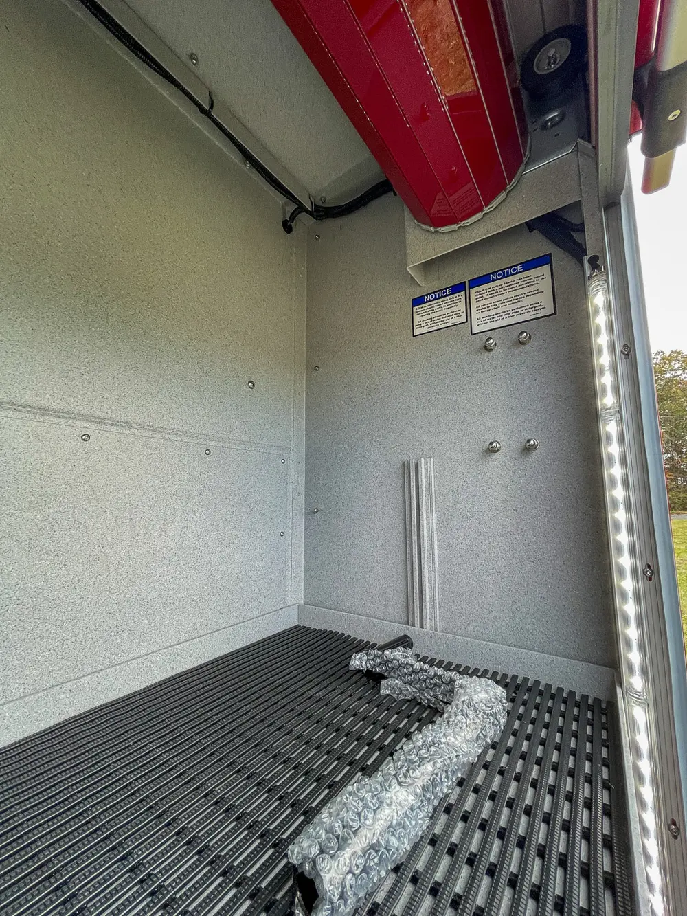 Compartment interior side wall with placards and mounting bolts.