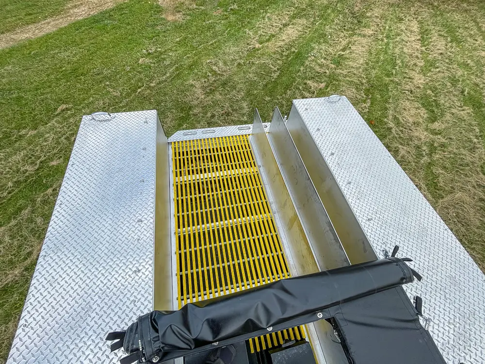 High rear view down yellow grated center channel toward cab.