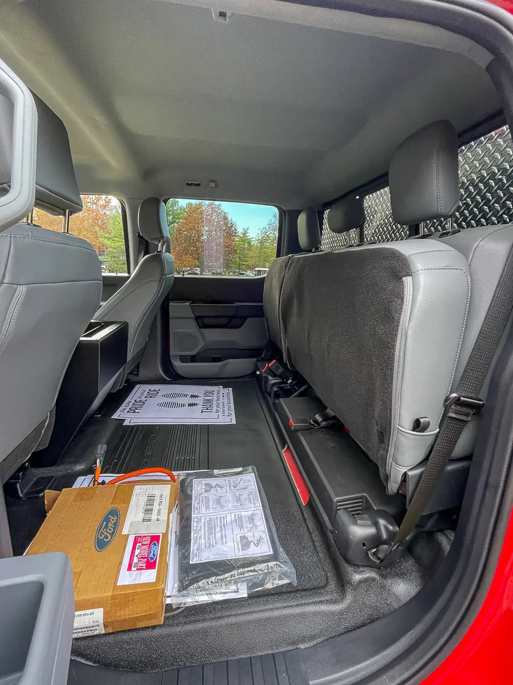 Rear cabin legroom view behind front seats from open door.